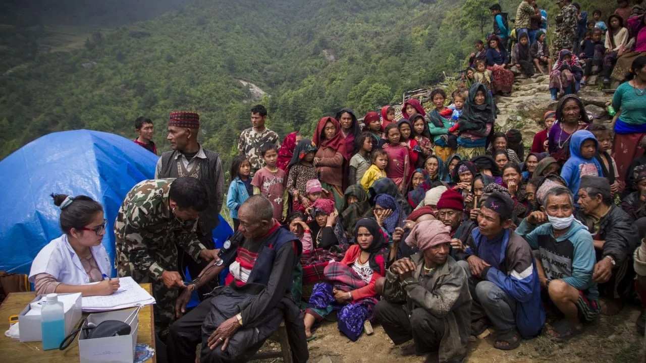 Families gather for emergency assistance following flooding in Nepal.